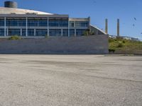 a skateboarder going around on a concrete course in front of a large building