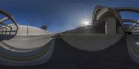 the skateboarder is attempting tricks on the concrete surface of the ramp, viewed through fish eye lens