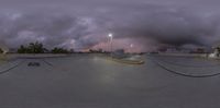 a skate boarder performs his stunt on a dark cloudy day at night - like