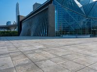 a skateboarder is standing in front of a building with a glass windowed facade