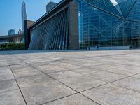 a skateboarder is standing in front of a building with a glass windowed facade