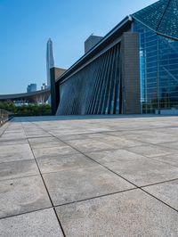 a skateboarder is standing in front of a building with a glass windowed facade