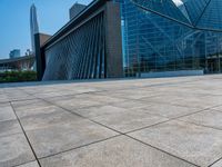 a skateboarder is standing in front of a building with a glass windowed facade