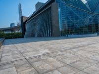 a skateboarder is standing in front of a building with a glass windowed facade