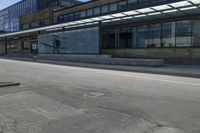 a skateboarder on the street in front of a building in an empty lot