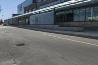 a skateboarder on the street in front of a building in an empty lot