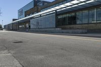 a skateboarder on the street in front of a building in an empty lot