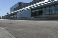 a skateboarder on the street in front of a building in an empty lot