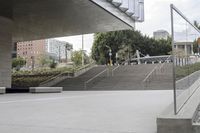 the skateboarder is going up the steps near the building where it stands the other direction