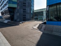 a skateboarder grinding his board on the road in front of buildings of an urban area