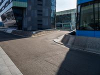 a skateboarder grinding his board on the road in front of buildings of an urban area