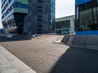 a skateboarder grinding his board on the road in front of buildings of an urban area