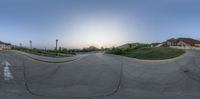 a skateboarder is at the top of a half pipe ramp at sunset with houses in background