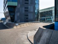 the skate boarder is skating outside of the building near a curbed area that is empty