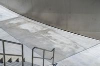 the skateboarder is getting ready to jump down the stairs in the air in front of an artistic building