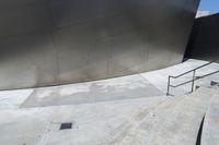 the skateboarder is getting ready to jump down the stairs in the air in front of an artistic building