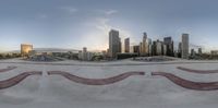 a skateboarder in mid air over a skate board ramp with a cityscape behind him