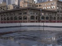 the skateboarder stands on a frozen skating rink in the city as the sun sets