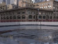 the skateboarder stands on a frozen skating rink in the city as the sun sets