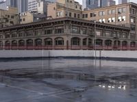 the skateboarder stands on a frozen skating rink in the city as the sun sets