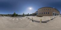 a 360 degree view of a skateboarder going down the ramp in front of a building