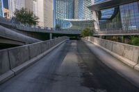 a man riding a skateboard down a long bridge next to high buildings, some with windows and other