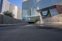 a man riding a skateboard down a long bridge next to high buildings, some with windows and other