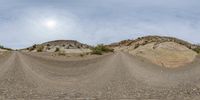 a skateboarder takes off from the bottom of a mountain in an arid area