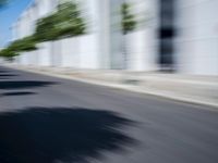 the skateboarder is going down the road in the blurry photo, which appears to be in motion