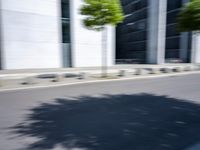 the skateboarder is going down the road in the blurry photo, which appears to be in motion