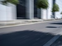 the skateboarder is going down the road in the blurry photo, which appears to be in motion