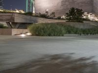 a man rides his skateboard on a street in front of a large, modern building