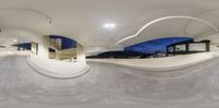 a skateboarder rides up the side of the ramp at night with an overhead view of buildings