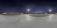 a skateboarder takes a mid - air shot in a parking lot at night