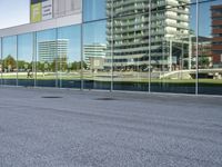 a skateboarder riding past an office building with large windows on either side of it