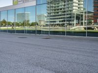 a skateboarder riding past an office building with large windows on either side of it