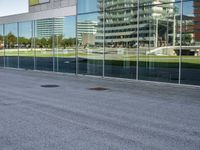 a skateboarder riding past an office building with large windows on either side of it