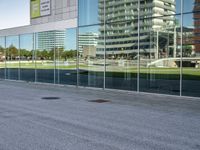 a skateboarder riding past an office building with large windows on either side of it