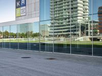 a skateboarder riding past an office building with large windows on either side of it