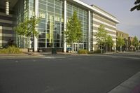 a person riding a skateboard in front of an office building or library building and street