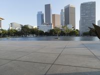 a skateboarder on a cement surface overlooking the water and tall buildings in a city