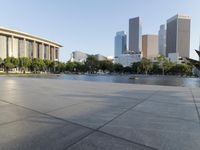 a skateboarder on a cement surface overlooking the water and tall buildings in a city