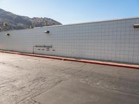 a skateboarder is riding down a cement street in a white tiled building area