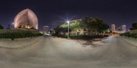 a 360 view of a skateboarder in a park at night with a city and buildings in the background