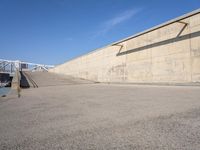 skateboarder practicing his tricks in front of an empty concrete wall in a city