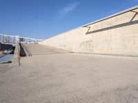 skateboarder practicing his tricks in front of an empty concrete wall in a city