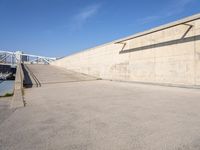 skateboarder practicing his tricks in front of an empty concrete wall in a city