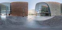 the reflection of a skateboarder on a ramp at an outdoor park area in front of some buildings