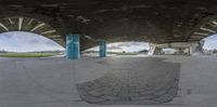 a skateboarder rides up the edge of a ramp inside a building next to two large arches