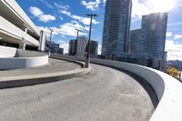 a skateboarder in the middle of a ramp near buildings and lights on a sunny day